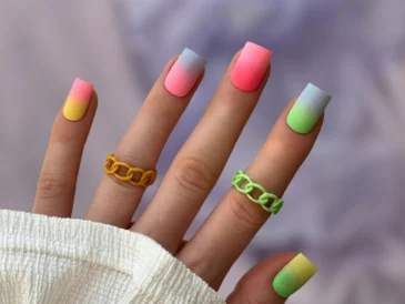 Dłoń z długimi paznokciami w gradientowych kolorach