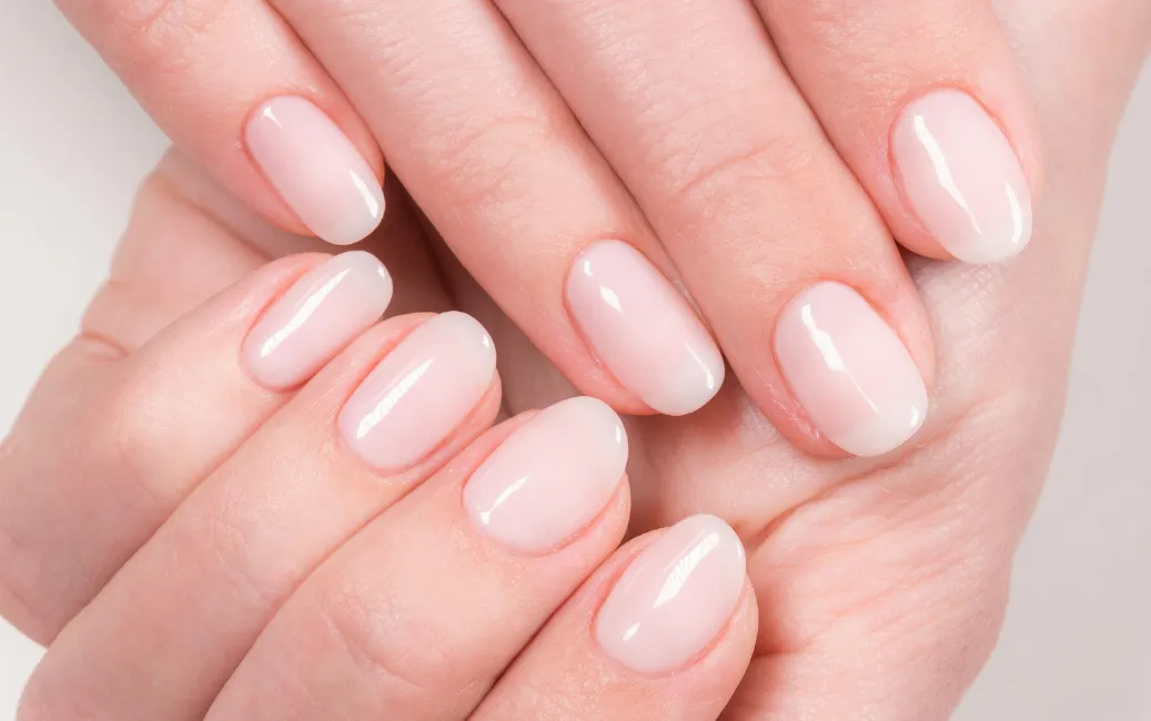 Zbliżenie na dłonie z naturalnymi, błyszczącymi i zadbanymi paznokciami