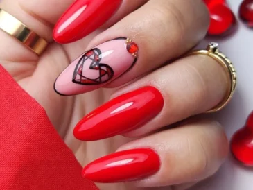 Dłoń z długimi paznokciami pomalowanymi na intensywną czerwień z akcentem na jednym paznokciu